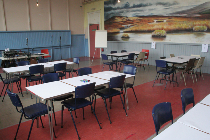 Tables in Kinning Park Complex community centre, a painting on the wall