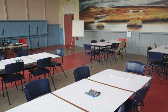 Tables in Kinning Park Complex community centre, a painting on the wall