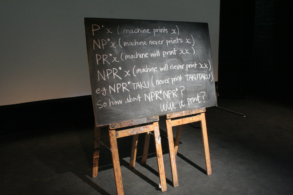 A blackboard with text in front of a screen