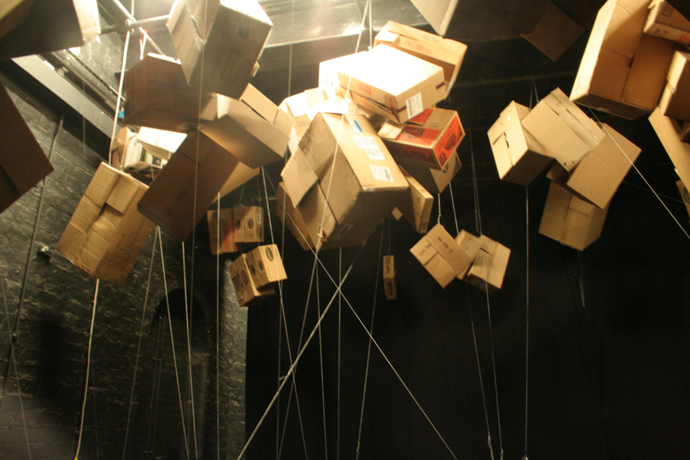 Suspended Cardboard boxes in a theatre space