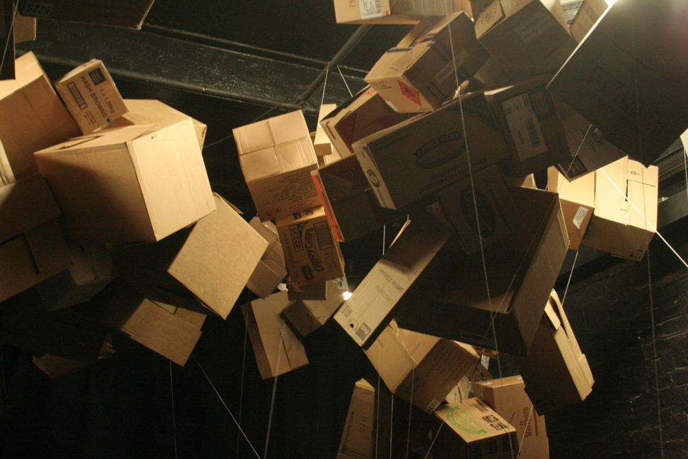 Cardboard boxes suspended in bunches from cords