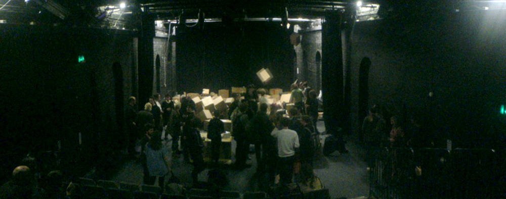 wide angle shot of theatre space with audience and many many boxes