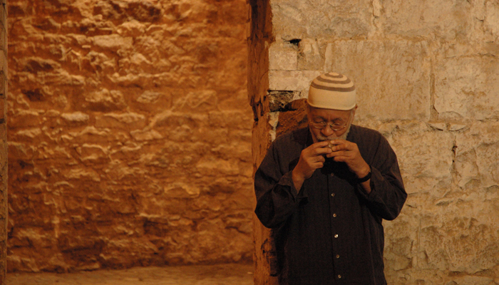 Akio Suzuki blowing into a small object in an ice house