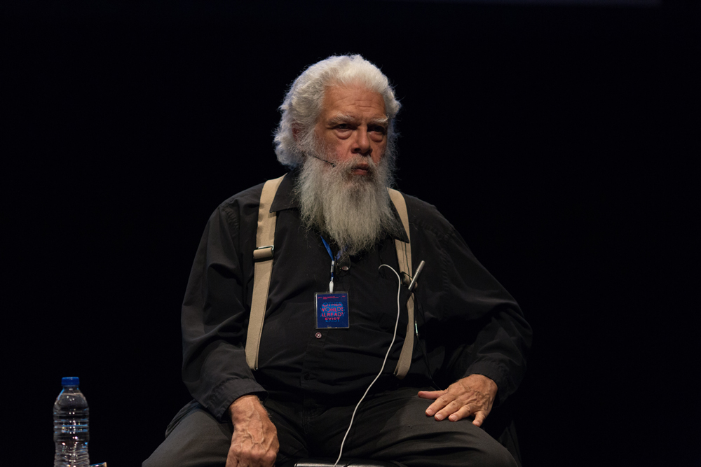Samuel Delany wearing black and bearded with one hand in his lap