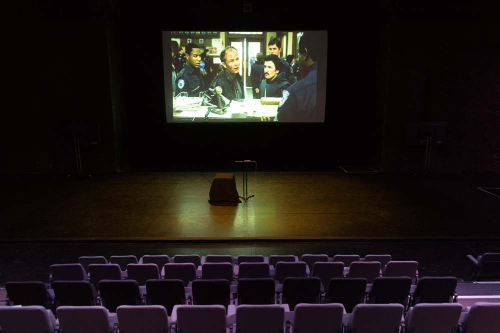 A scene from Robocop film projected in a theatre space