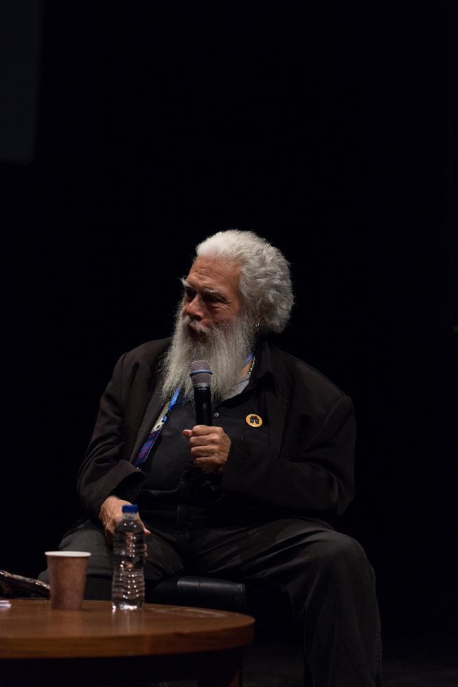 Samuel Delany holding a microphone on stage during a discussion