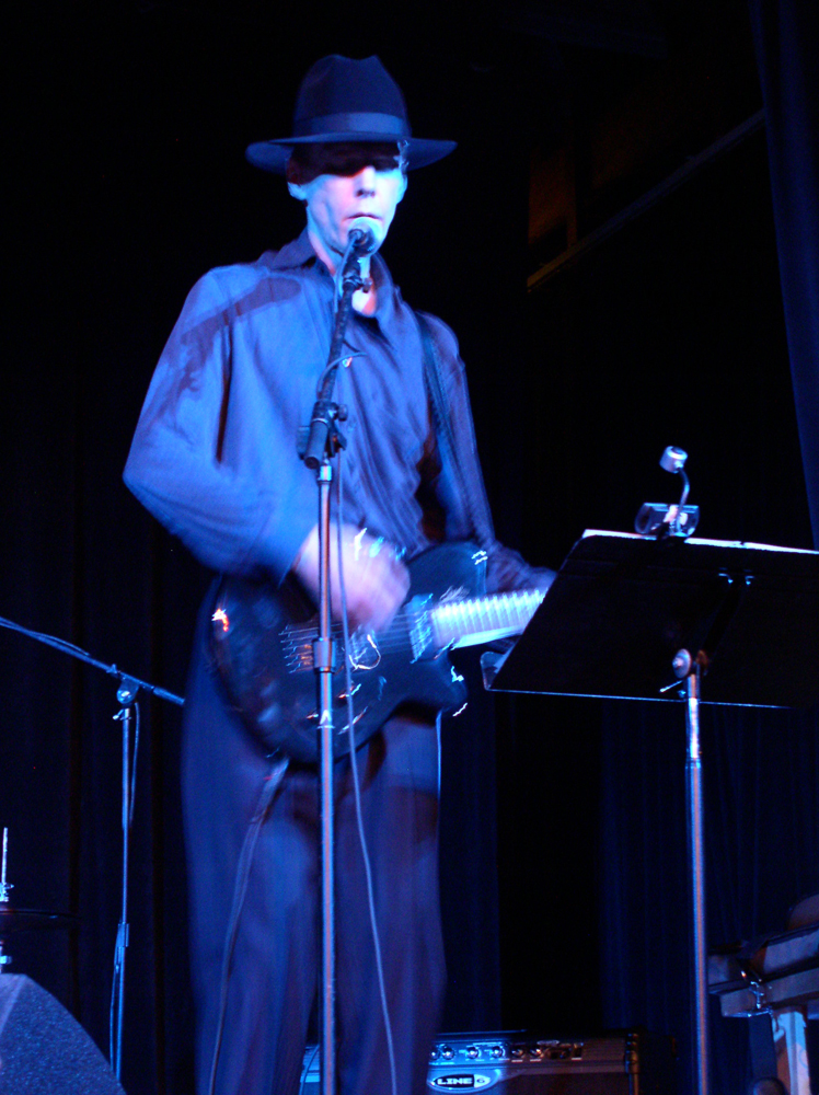 Jandek playing an electric guitar on stage in Austin 