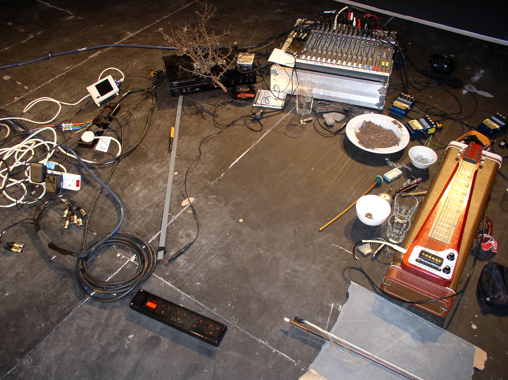 Steve Roden's pedal steel guitar, bowl of straw, pedals, mixer, branch