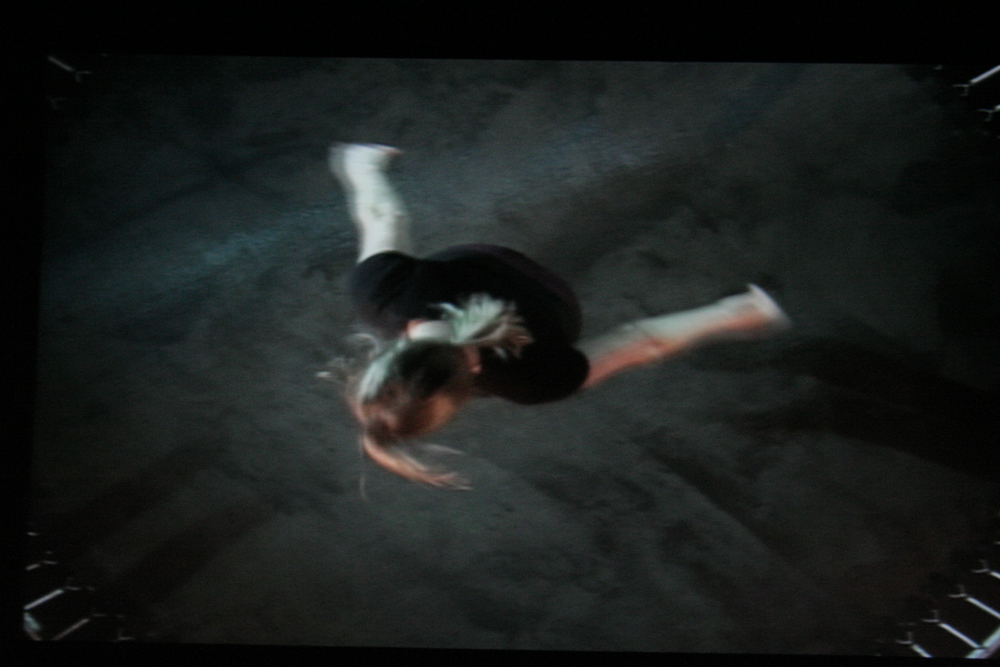 Projection still of Aileen jumping on a trampoline, from above