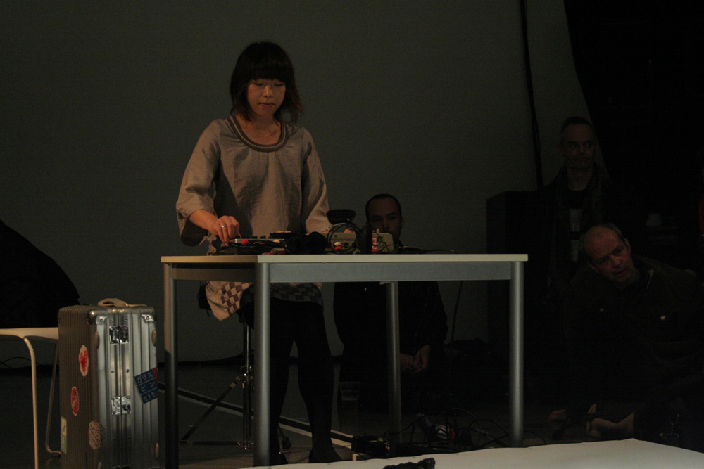 Sachiko M operating a sampler at a table