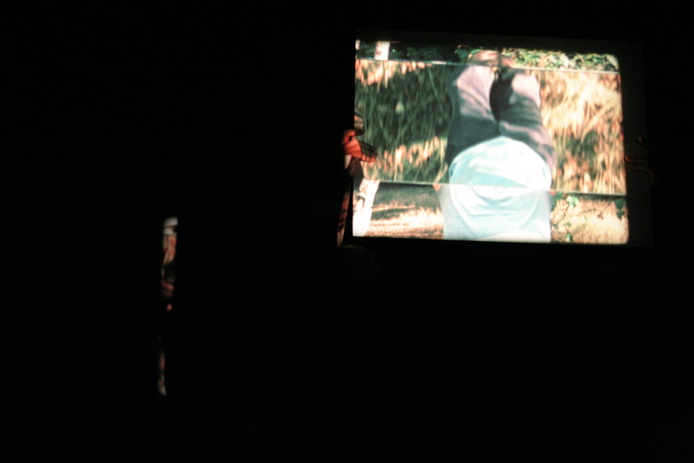 Guy sherwin holding a mirror showing a projection of himself with another mirror