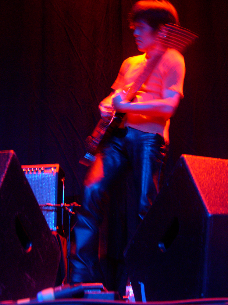 A guitarist lit in pink light on stage at MLFC 05