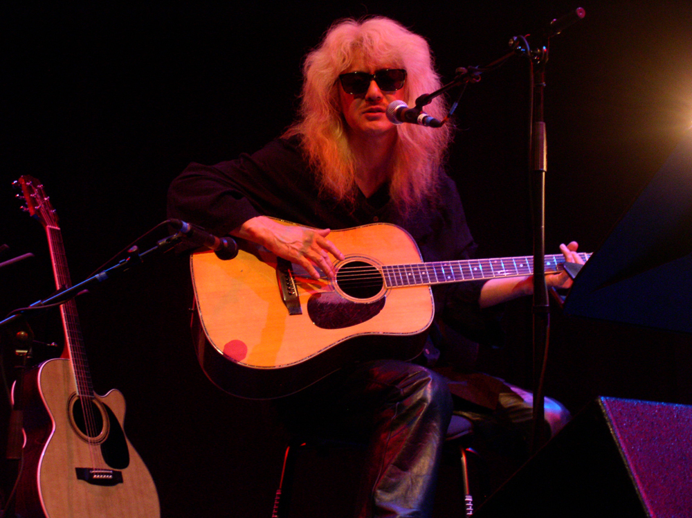 Shuji Inaba playing acoustic guitar and singing on stage at MLFC 05
