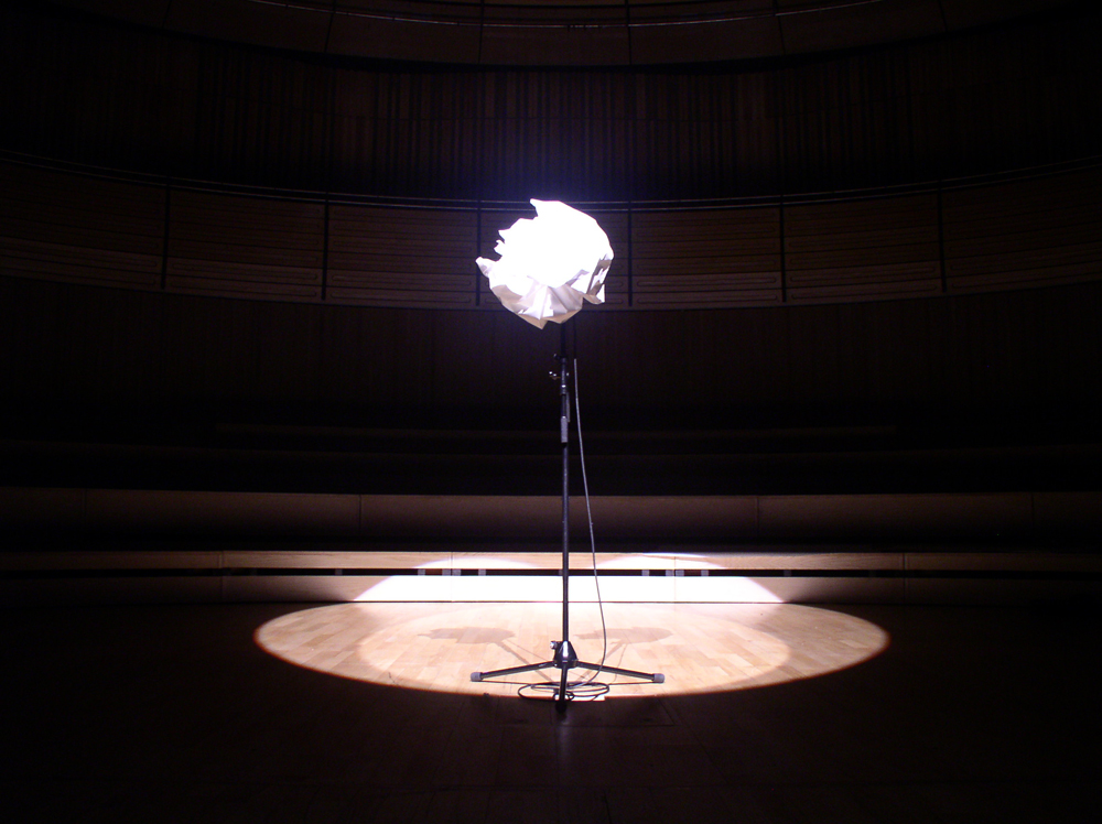 A microphone wrapped in white paper on a mic stand on stage