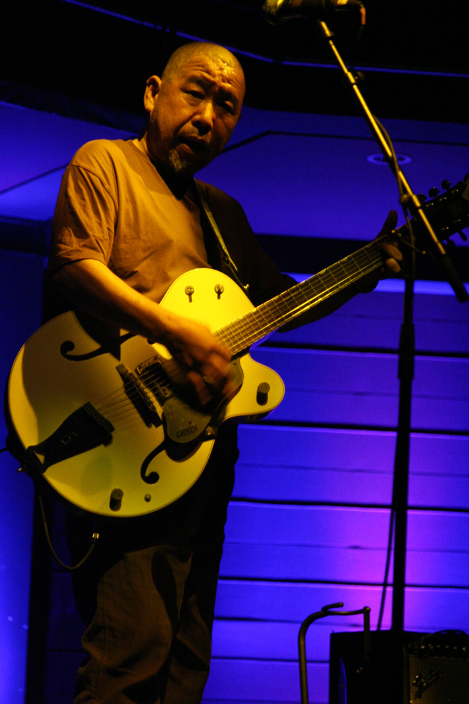 Kan Mikami playing a guitar on stage at MLFC 07