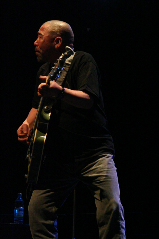 Kan Mikami playing a guitar on stage at MLFC 07