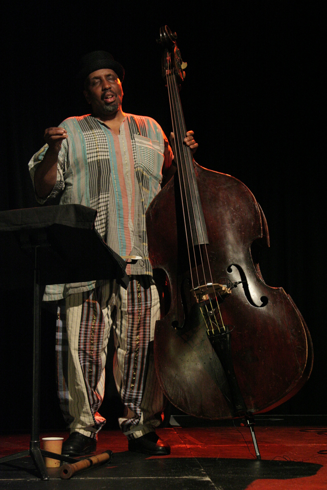 William Parker standing in concentration next to a double bass