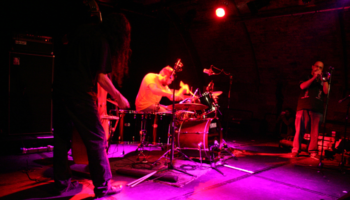 Eye Contact group on stage in pink light at INSTAL 06