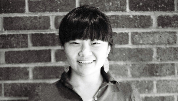 Okkyung Lee Portrait against a brick wall
