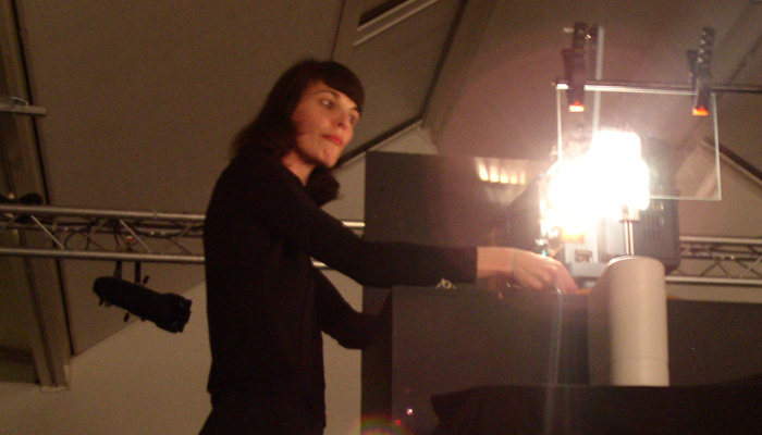 Sandra Gibson adjusting a slide in front of a projector
