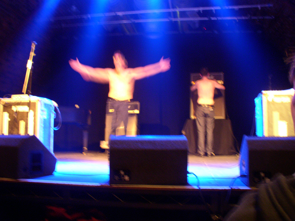 Whitehouse shirtless on stage in the arches waving their arms