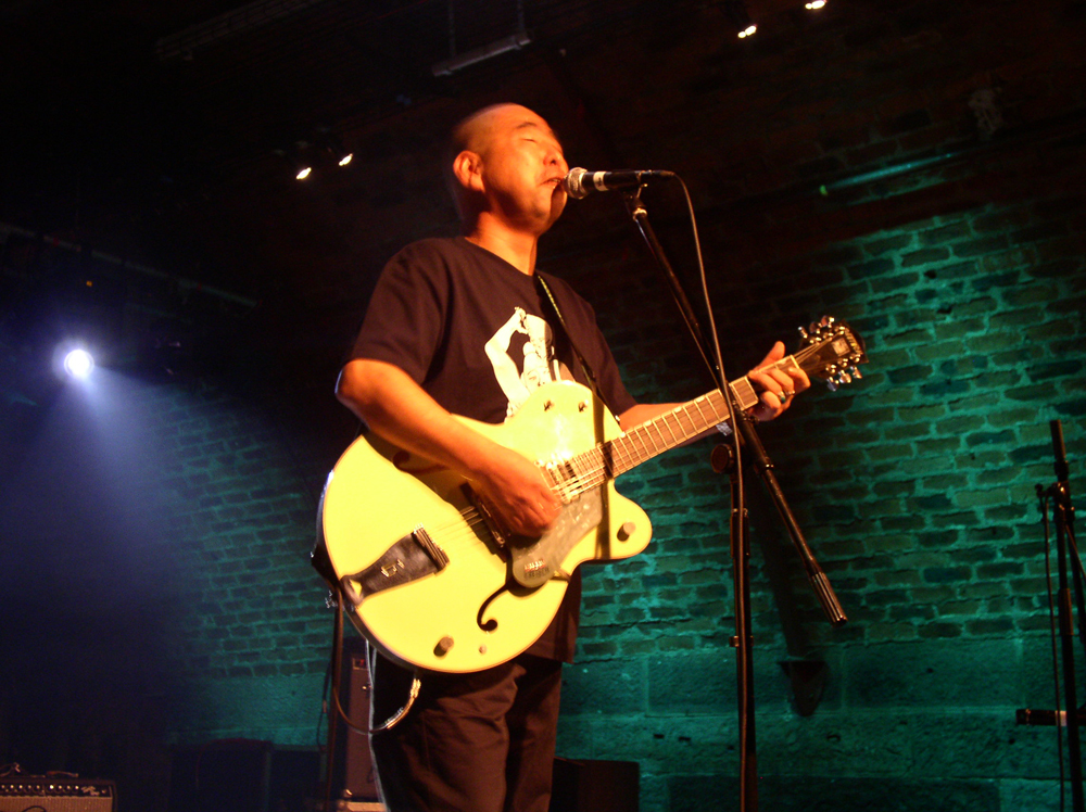 Kan Mikami playing guitar and singing at INSTAL 04