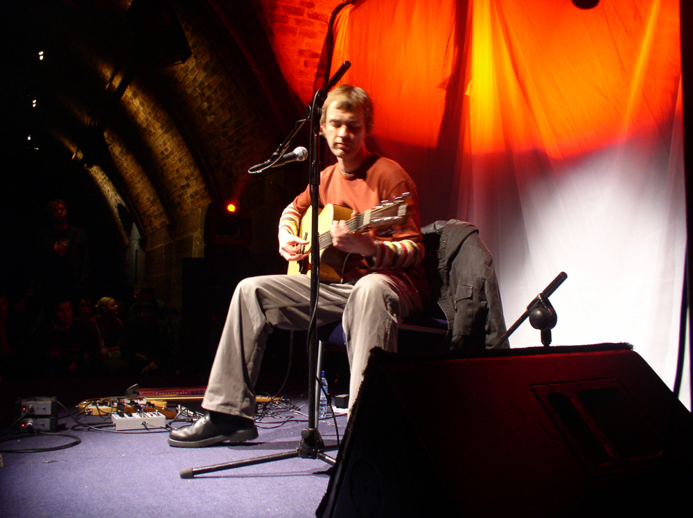 Richard Youngs playing acoustic guitar on stage at INSTAL 04