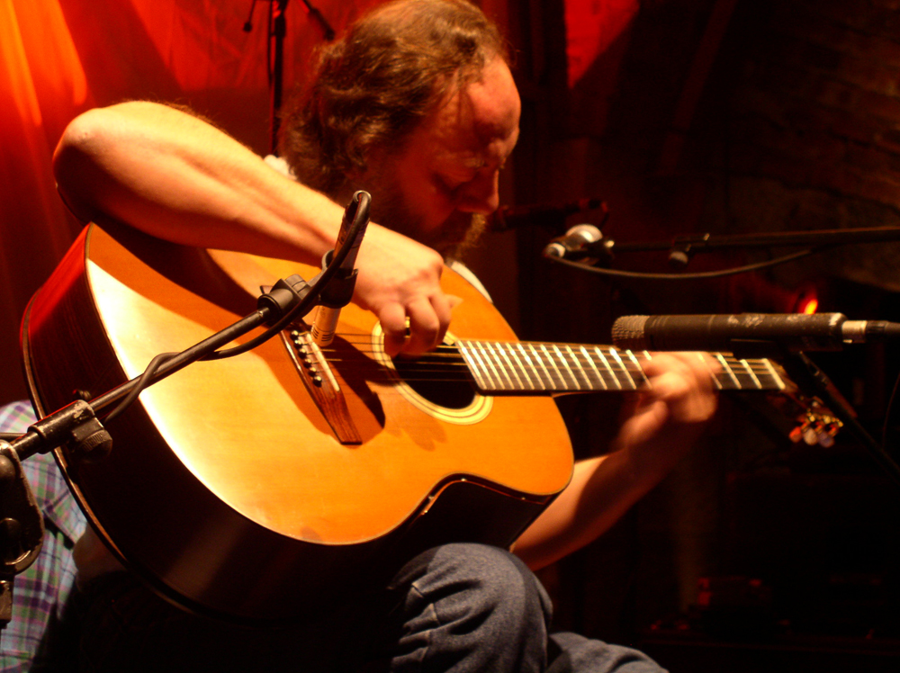 Steffen Basho-Junghans playing an acoustic guitar at INSTAL 04 