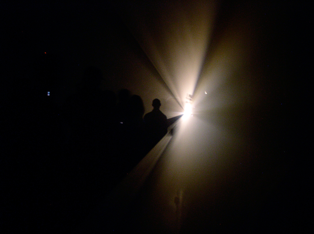 Light coming from a localised point spreading out near an audience