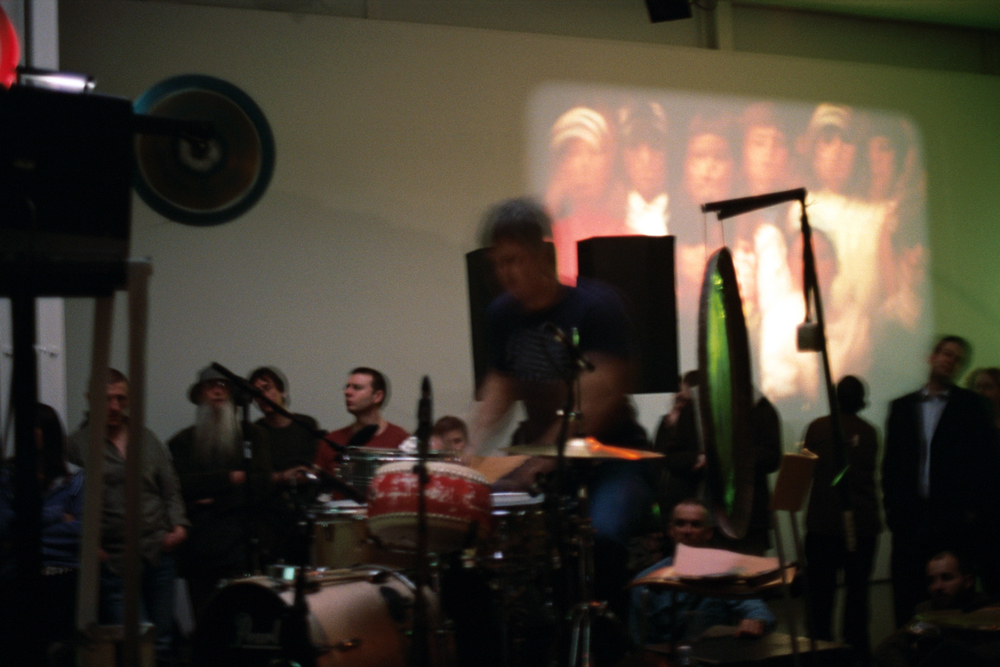 Tim Barnes playing drums near a projection at KYTN 04