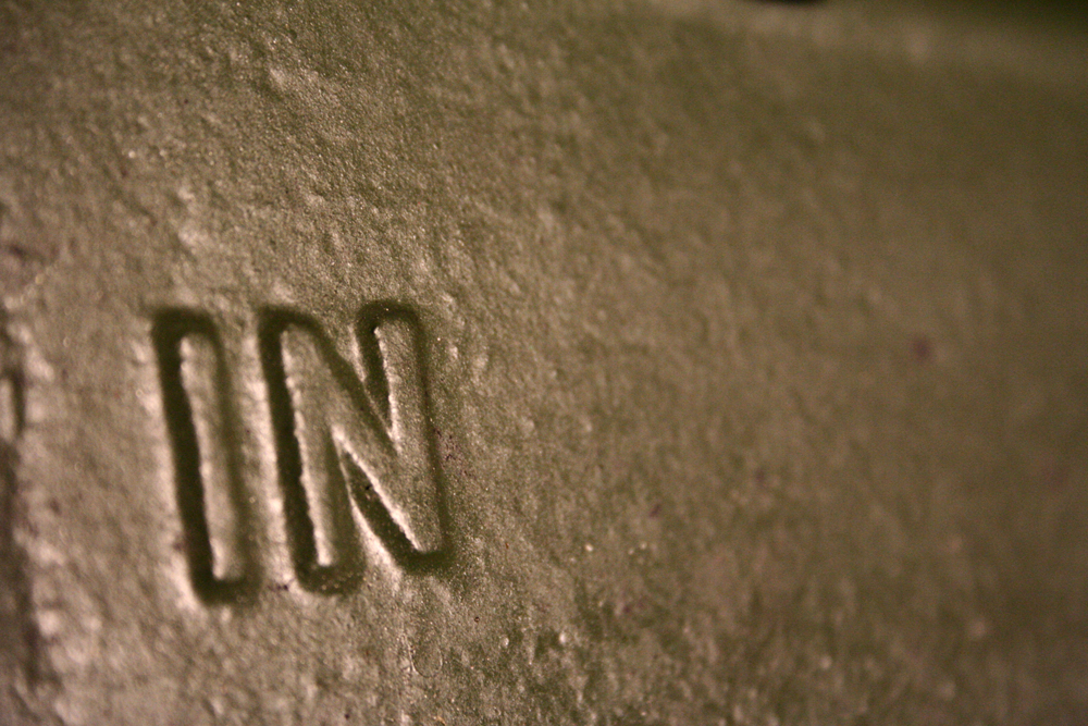 Close up of a metallic surface with the word 'IN' in relief 