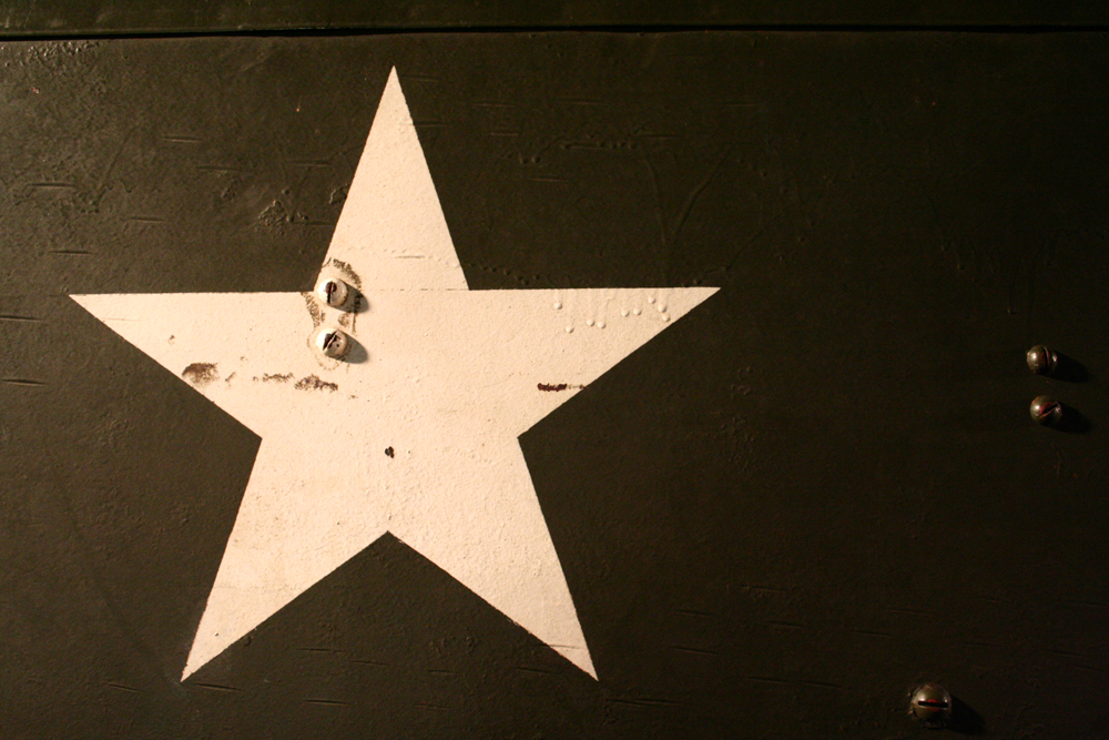 A white star painted on a black oil tank or similar metal container