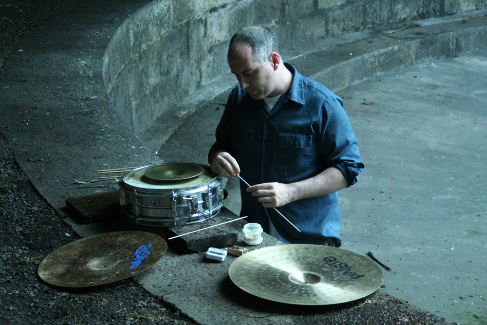 Sean Meehan selecting a stick from several sticks near some cymbals