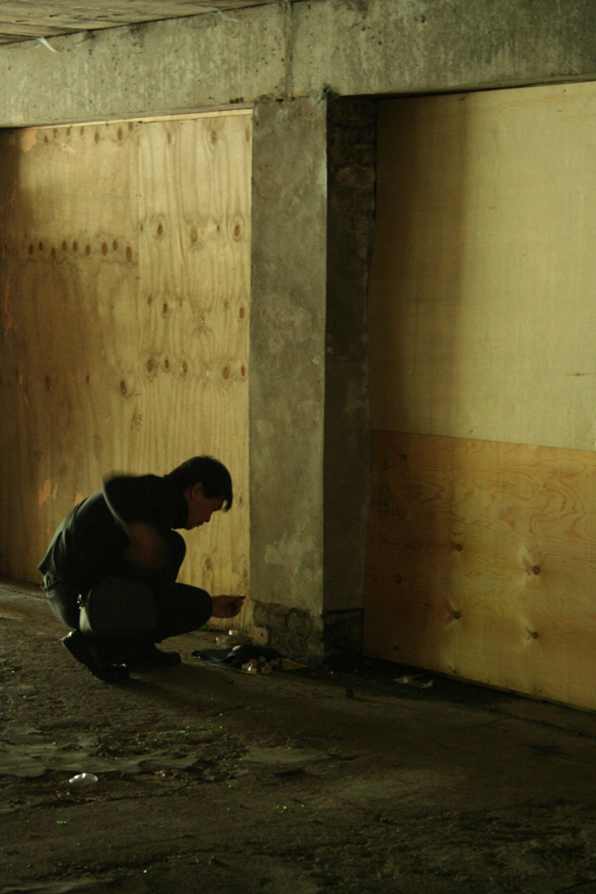 Ikuru Takehashi working with small objects near plywood boards