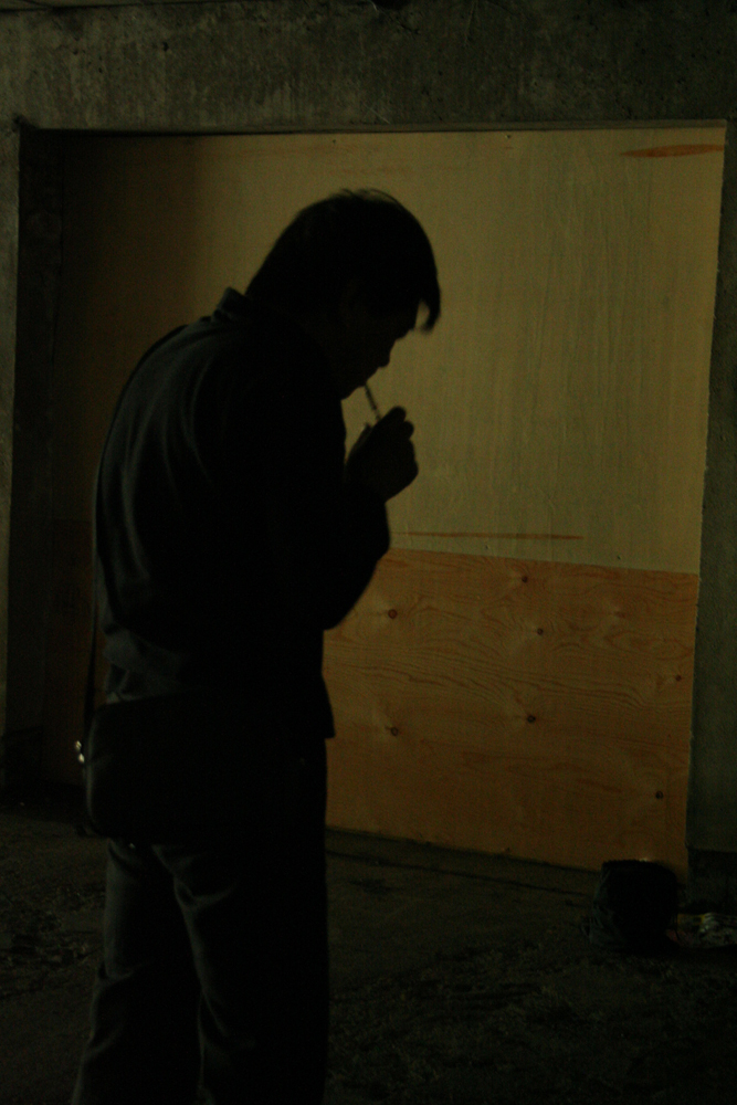 Ikuru Takehashi blowing a small instrument in an underpass