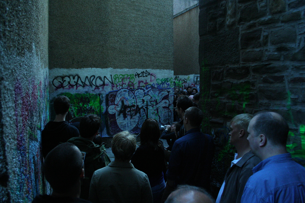 Backstreet of Dundee with an audience in a confined space