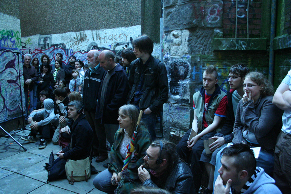 An audience assembled in a back street of Dundee