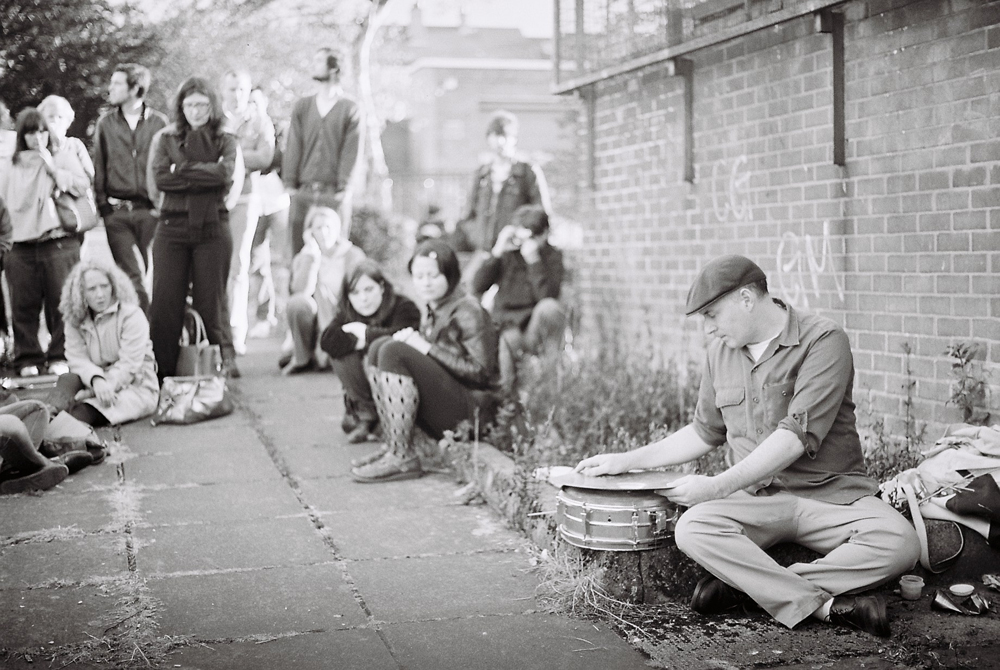 Sean Meehan sitting on the ground with snare and cymbals