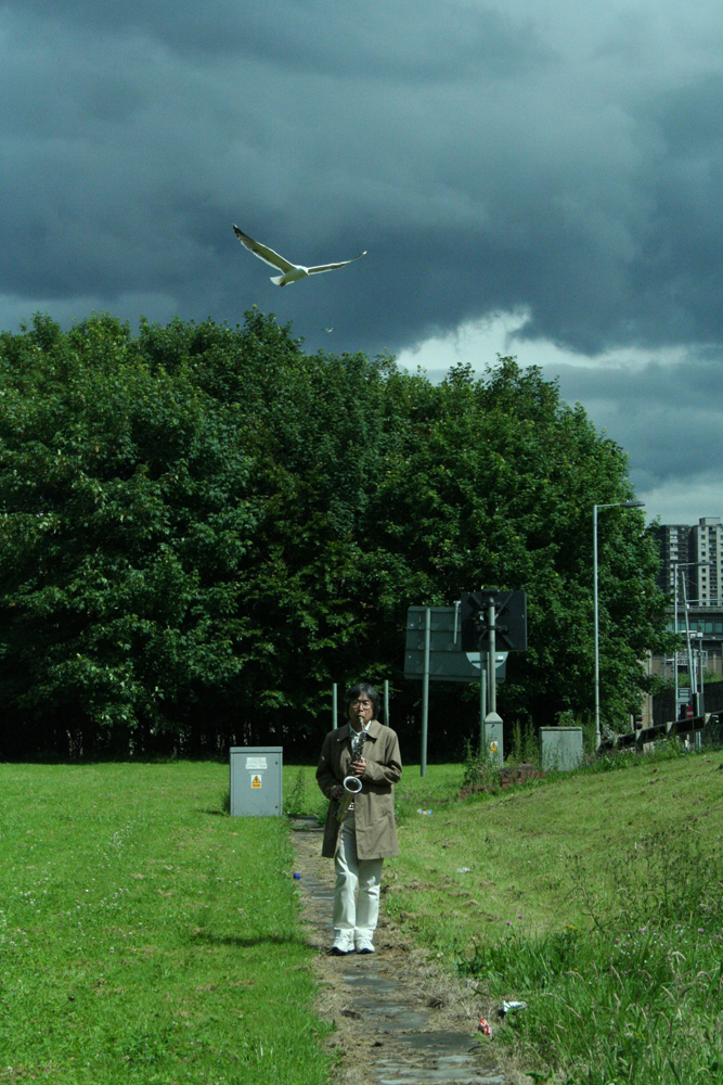 Tamio with seagull near a motorway with dark clouds behind