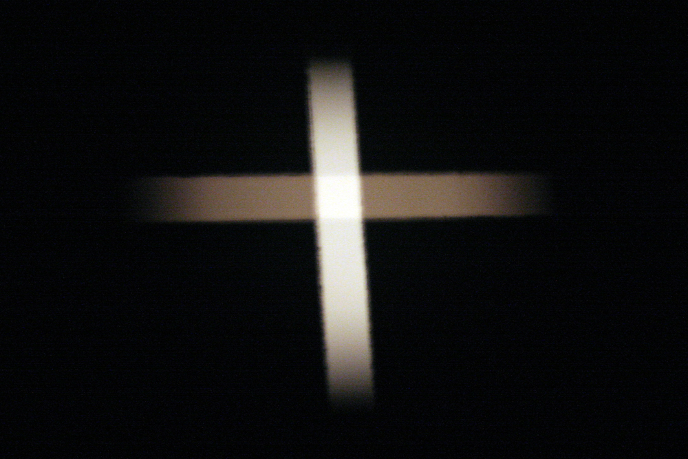 A white cross projected on a screen 