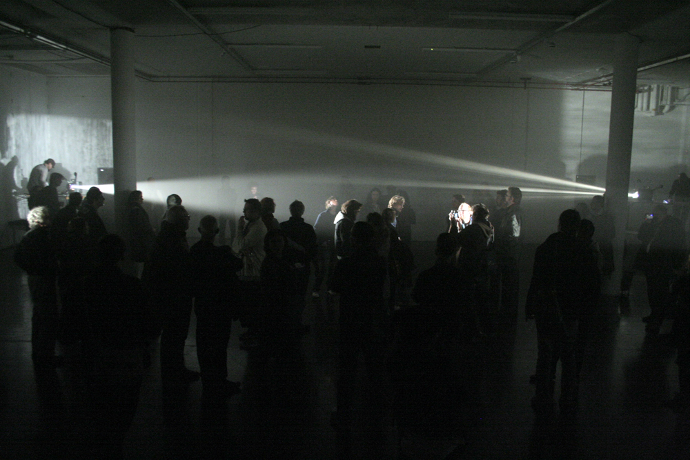 A room of people caught between two projectors