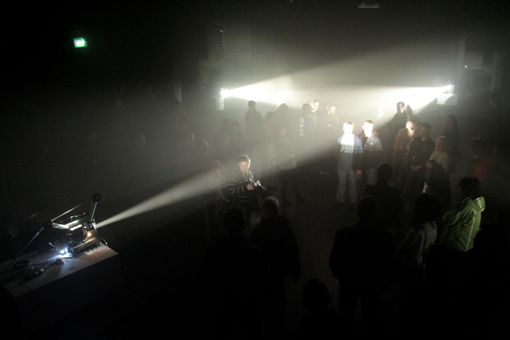 Beams of light fanning out across an audience from different directions