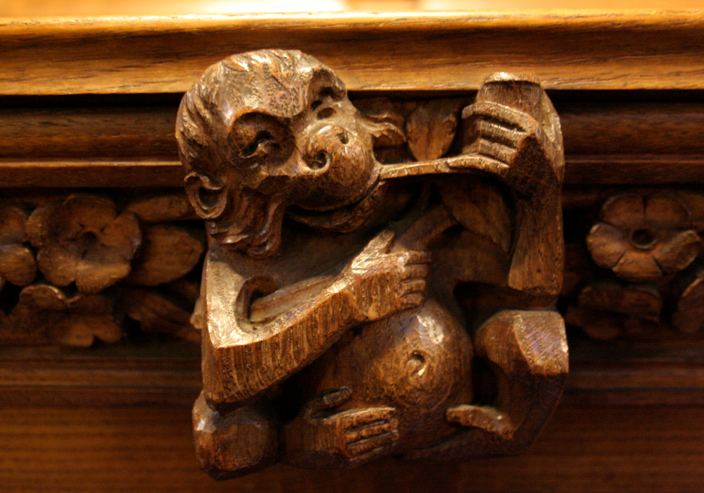 A wooden carved monkey smokes a pipe