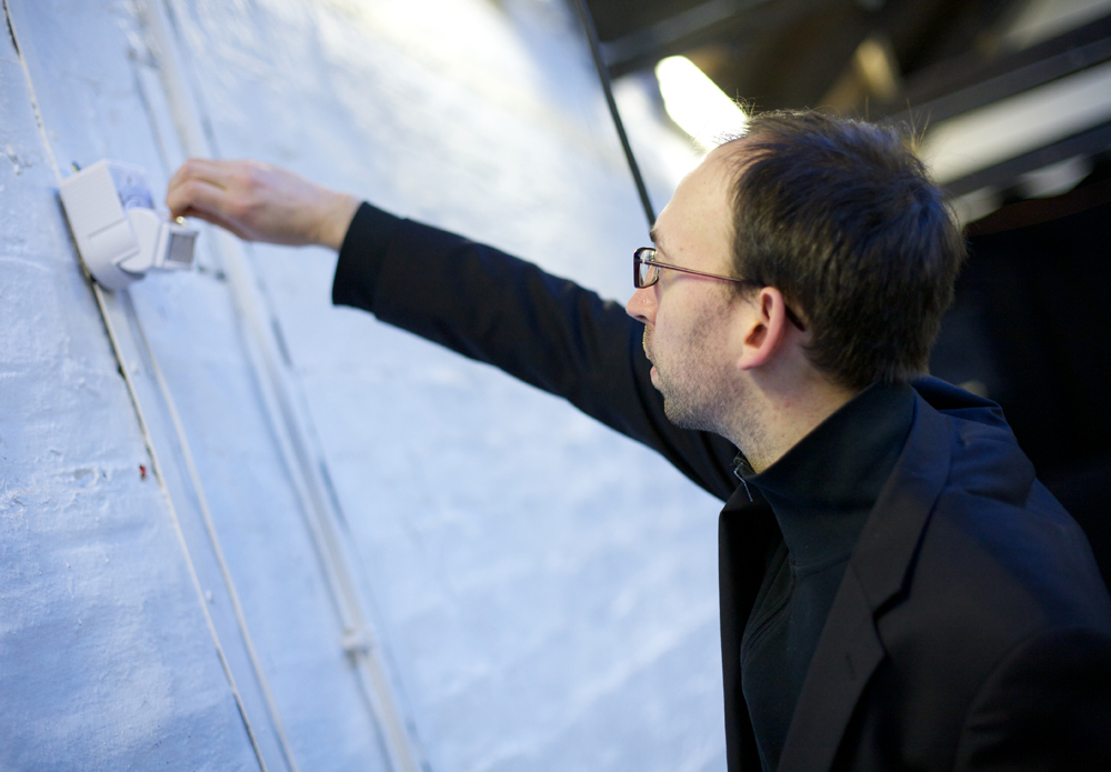 Matthew Saladin Adjusts a movement sensor in Tramway's studio space