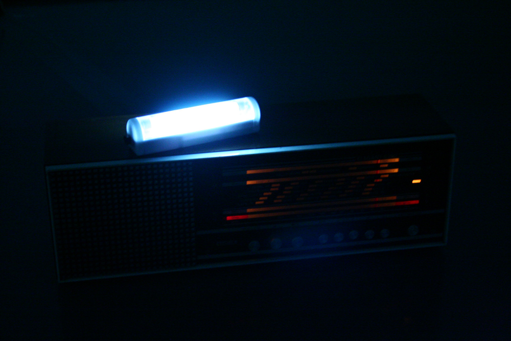Close up of a radio with a glowing fluorescent tube on top