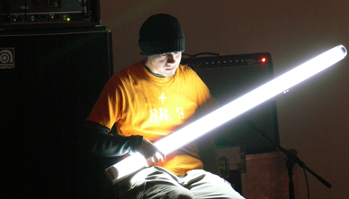 Atsuhiro Ito holding a glowing fluorescent tube