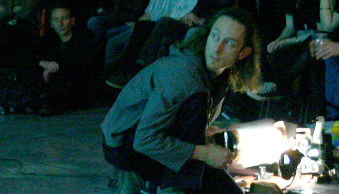 Keith Evans kneeling down near a projector