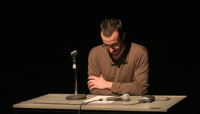 Loic sitting at a desk during a performance at UNINSTAL