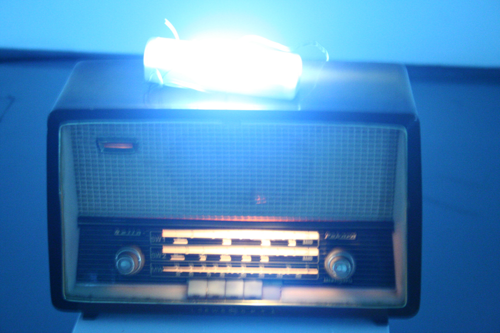 An old radio with a fluorescent light on top