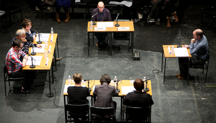 Groups of people at tables with microphones and papers